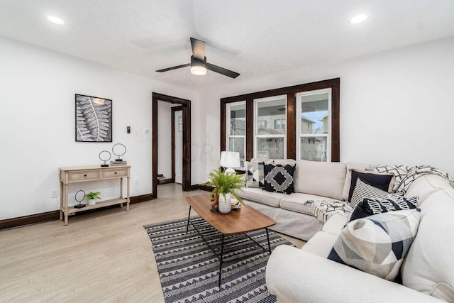 living room with ceiling fan and light hardwood / wood-style flooring