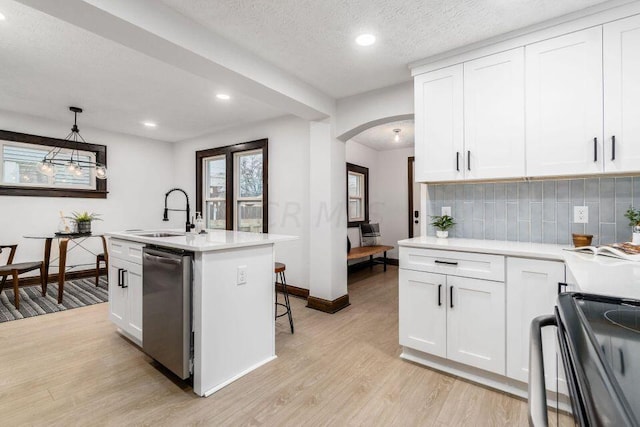 kitchen featuring dishwasher, stove, white cabinetry, and hanging light fixtures