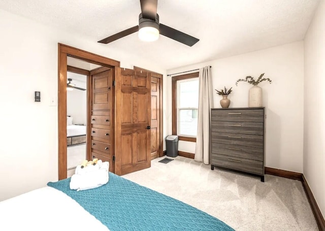 carpeted bedroom with ceiling fan and a textured ceiling