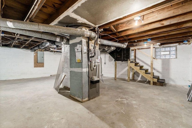 basement featuring electric panel and heating unit