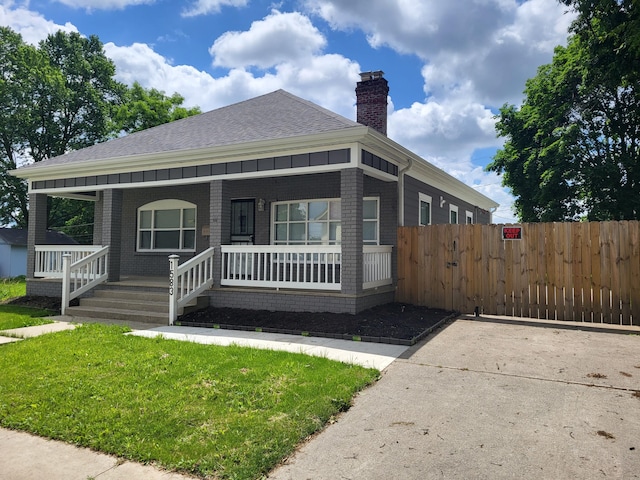 view of front facade featuring covered porch and a front yard