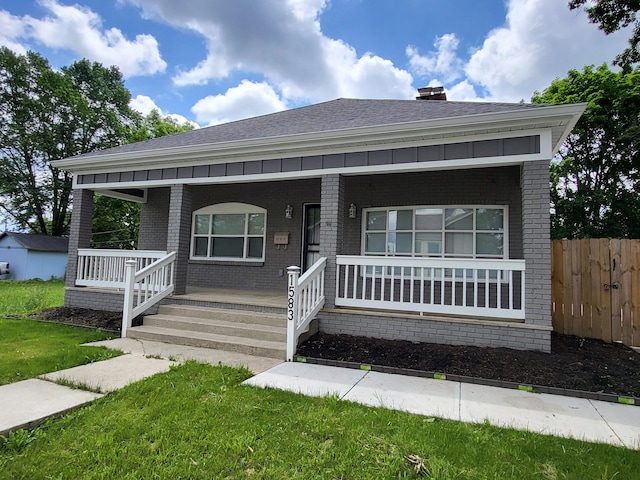 view of front facade with covered porch and a front lawn