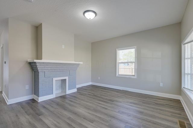 unfurnished living room with a healthy amount of sunlight, light hardwood / wood-style floors, and a fireplace