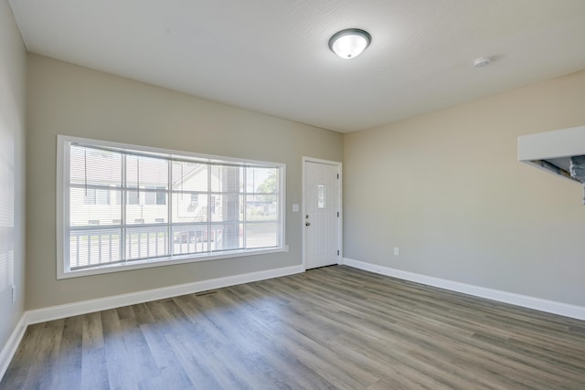 unfurnished room with a wealth of natural light and hardwood / wood-style floors