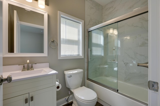 full bathroom featuring vanity, toilet, and bath / shower combo with glass door