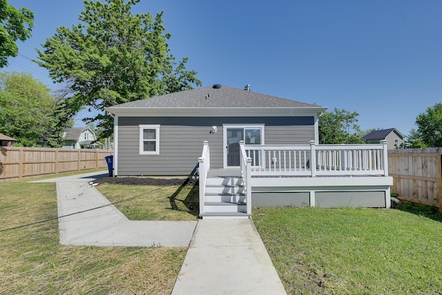 rear view of property with a wooden deck and a yard