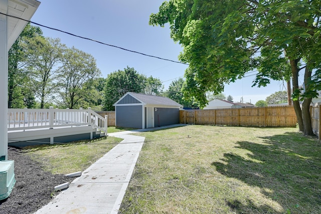 view of yard with a wooden deck and a storage shed