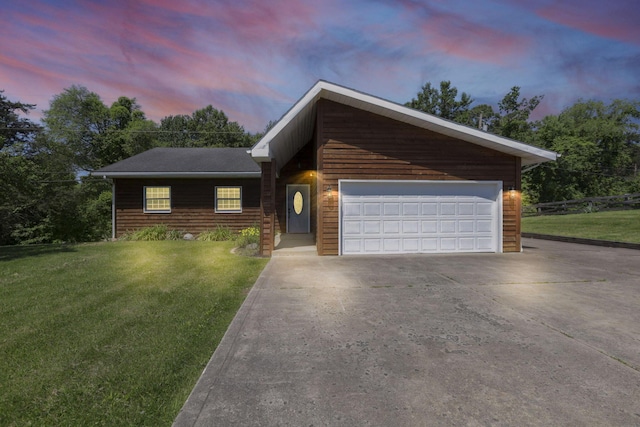 view of front of home with a garage and a yard