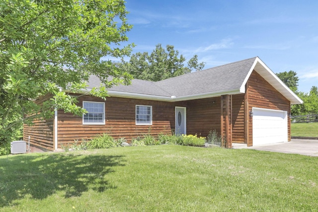 cabin with a garage, a front lawn, and central air condition unit