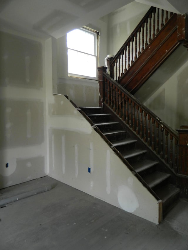 stairs featuring concrete flooring