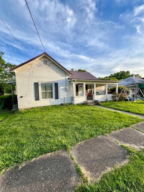 view of front of home with a front yard and covered porch