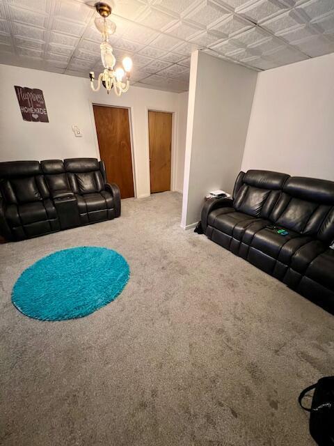 carpeted living room with a notable chandelier