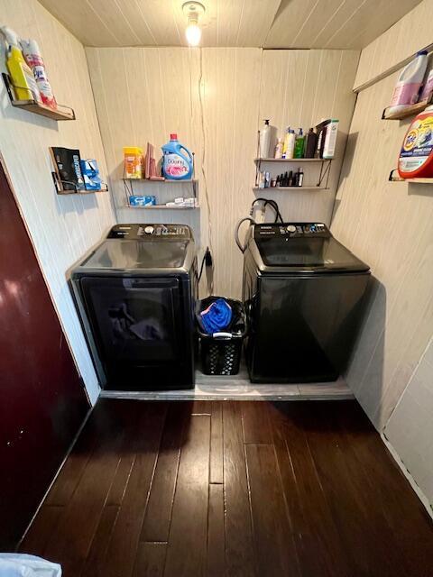 clothes washing area with washer and dryer and dark wood-type flooring