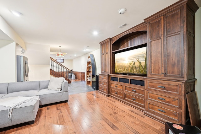 living room with wooden walls and light wood-type flooring