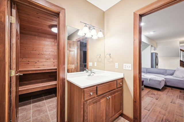 bathroom with hardwood / wood-style floors, vanity, and washer / clothes dryer