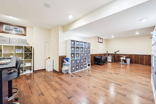 office space with light hardwood / wood-style floors and wood walls