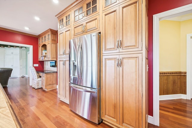 kitchen with hardwood / wood-style floors, stainless steel fridge, and crown molding