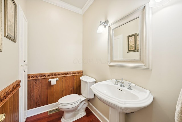 bathroom featuring hardwood / wood-style flooring, toilet, ornamental molding, and sink