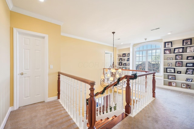 corridor with a chandelier, crown molding, and light colored carpet