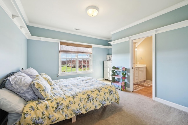 carpeted bedroom with ensuite bathroom and crown molding