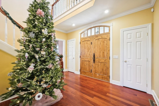 foyer entrance with dark hardwood / wood-style flooring and ornamental molding