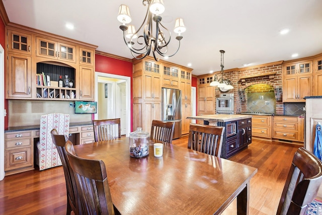 dining room with crown molding, dark wood-type flooring, and a chandelier