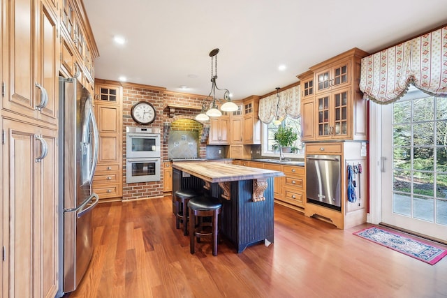 kitchen featuring appliances with stainless steel finishes, sink, dark hardwood / wood-style floors, a kitchen island, and butcher block counters