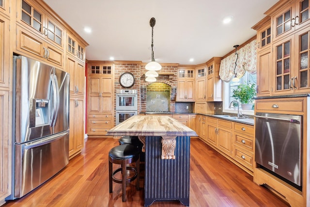 kitchen with pendant lighting, a center island, sink, and stainless steel appliances