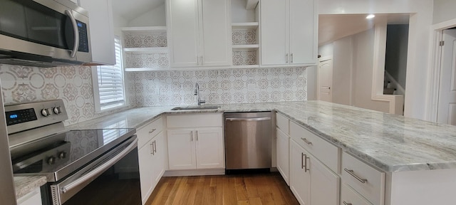 kitchen featuring light stone countertops, stainless steel appliances, sink, white cabinets, and light hardwood / wood-style floors