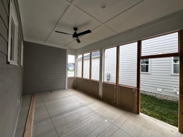 unfurnished sunroom with ceiling fan