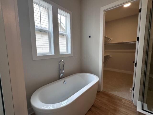 bathroom featuring wood-type flooring and separate shower and tub