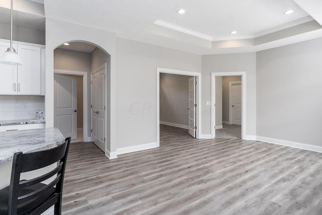 interior space featuring light hardwood / wood-style floors and a raised ceiling