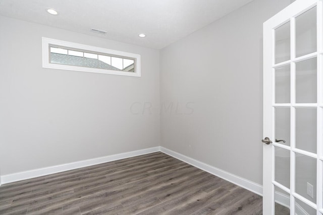 spare room featuring dark wood-type flooring and a textured ceiling