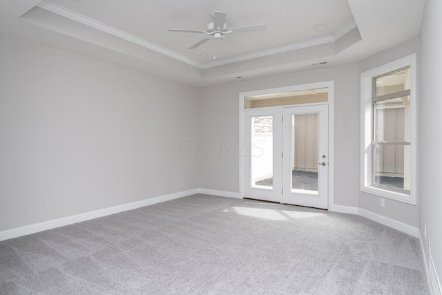 spare room with ceiling fan, a raised ceiling, carpet floors, and crown molding