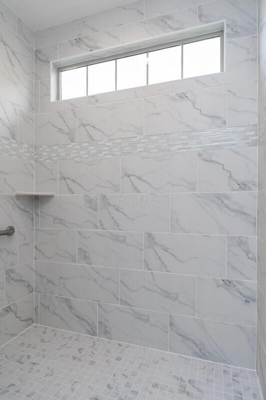 interior details with a tile shower