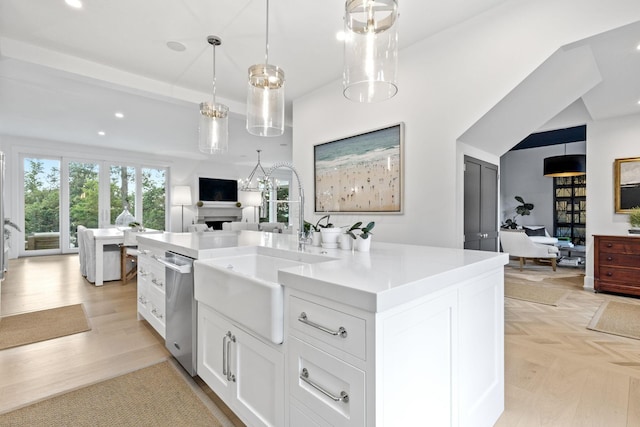 kitchen with dishwasher, white cabinets, sink, hanging light fixtures, and a kitchen island