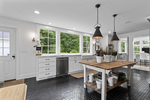 kitchen featuring plenty of natural light, white cabinets, hanging light fixtures, and stainless steel dishwasher