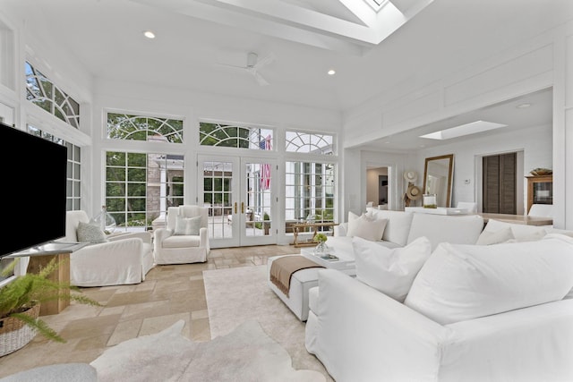 living room featuring ceiling fan, a towering ceiling, and french doors