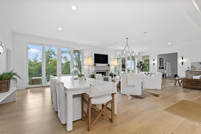 dining area featuring light wood-type flooring and a notable chandelier