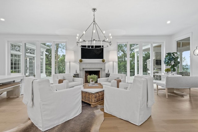 living room featuring french doors, light hardwood / wood-style floors, and a healthy amount of sunlight