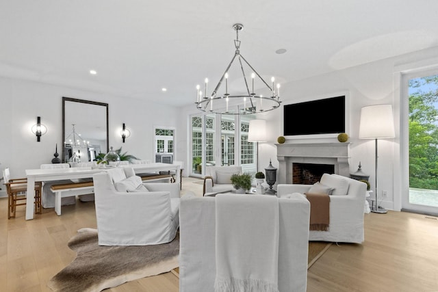 living room with a chandelier, light hardwood / wood-style flooring, and plenty of natural light