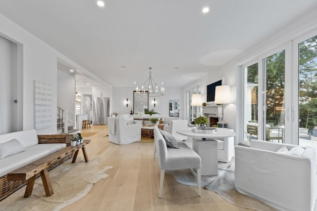 dining room with light wood-type flooring and an inviting chandelier