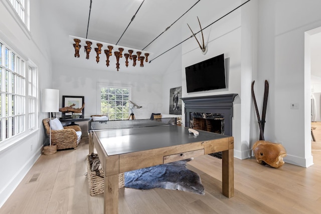 playroom featuring light wood-type flooring and lofted ceiling