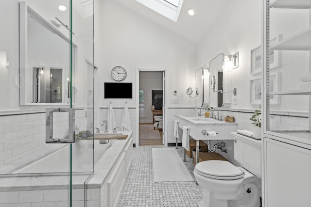 bathroom with a skylight, sink, high vaulted ceiling, and toilet