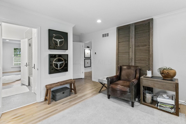 living area with hardwood / wood-style floors and crown molding