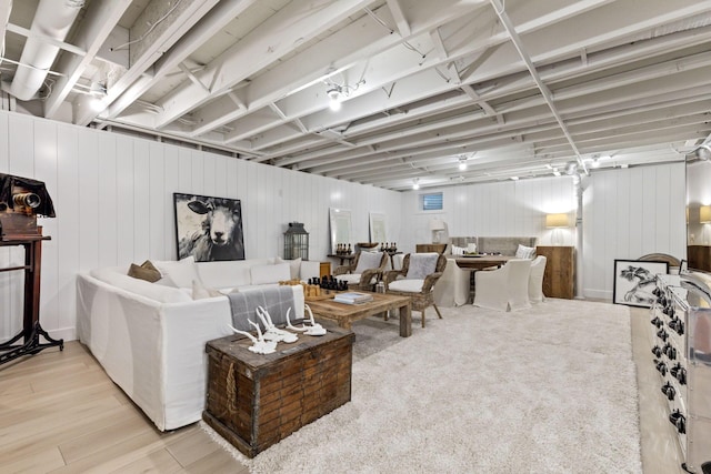 living room featuring light hardwood / wood-style floors and wooden walls