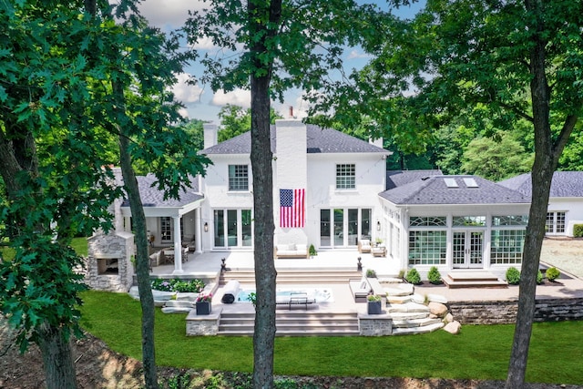 rear view of property featuring an outdoor living space with a fireplace, french doors, and a patio