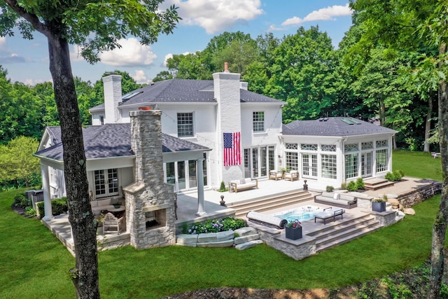 back of property featuring an outdoor living space with a fireplace, a patio area, and a lawn