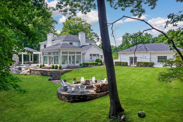 back of house featuring a yard, a patio, and an outdoor fire pit