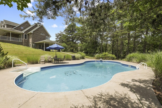 view of pool featuring a lawn and a patio area